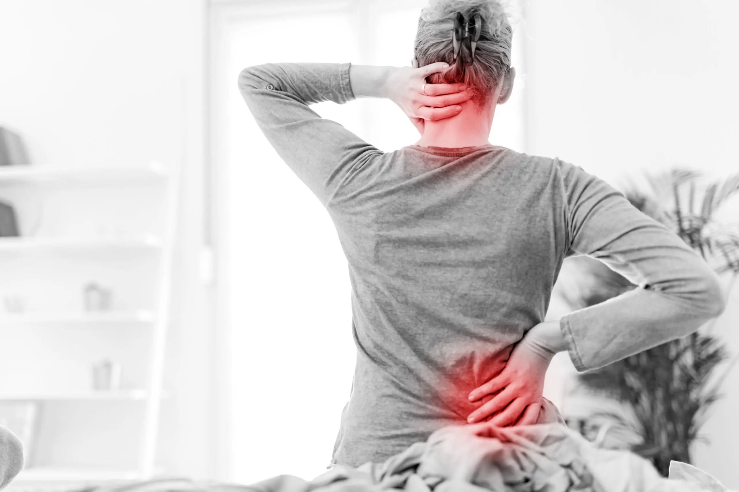 Woman waking up on the bed, morning stretching, pain in the back and neck.