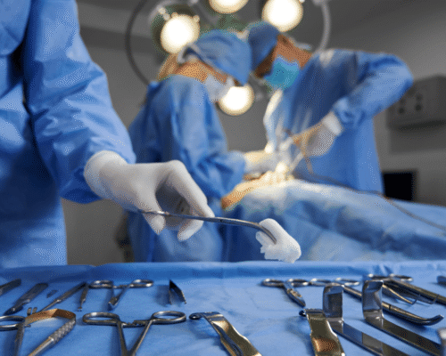 Surgeons in an operating room performing surgery with surgical tools in the foreground