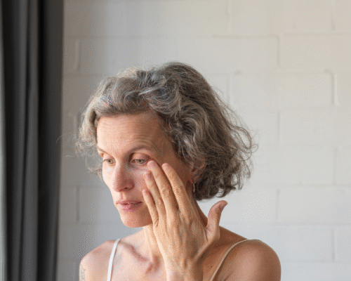 A concerned woman touching her eye, illustrating vision complications or discomfort following eye surgery and the potential impact of ophthalmological errors.