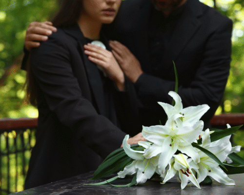 Family members mourning beside a casket with white lilies, representing grief and the potential for a wrongful death lawsuit following a kratom-related death.