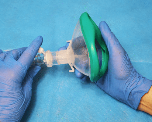 Medical professional wearing gloves prepares a pediatric anesthesia mask before surgery, representing anesthesia administration, medication safety, pediatric anesthesia complications, surgical care, and potential medical malpractice involving anesthesia dosage errors in children.