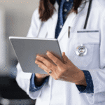 Female doctor in white coat reviewing patient information on a tablet, representing modern healthcare technology and potential delays in medical diagnosis