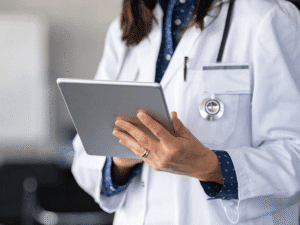 Female doctor in white coat reviewing patient information on a tablet, representing modern healthcare technology and potential delays in medical diagnosis