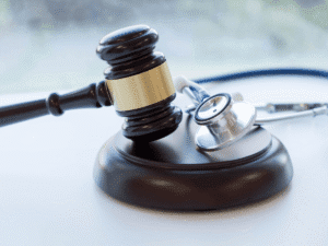 A judge’s gavel rests beside a stethoscope, symbolizing medical malpractice or healthcare litigation