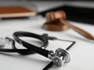 Close-up of a stethoscope and judge’s gavel on a desk, representing legal action in medical malpractice cases