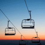 Empty ski lift chairs silhouetted against a colorful Colorado sunset sky, representing the landmark Annie Miller ski lift accident case where a jury awarded $20 million in damages for negligence at Crested Butte ski resort.