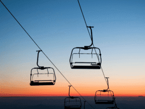 Empty ski lift chairs silhouetted against a colorful Colorado sunset sky, representing the landmark Annie Miller ski lift accident case where a jury awarded $20 million in damages for negligence at Crested Butte ski resort.