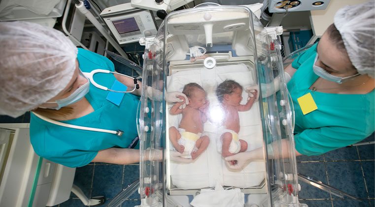 2 babies in NICU being cared for by 2 attendants